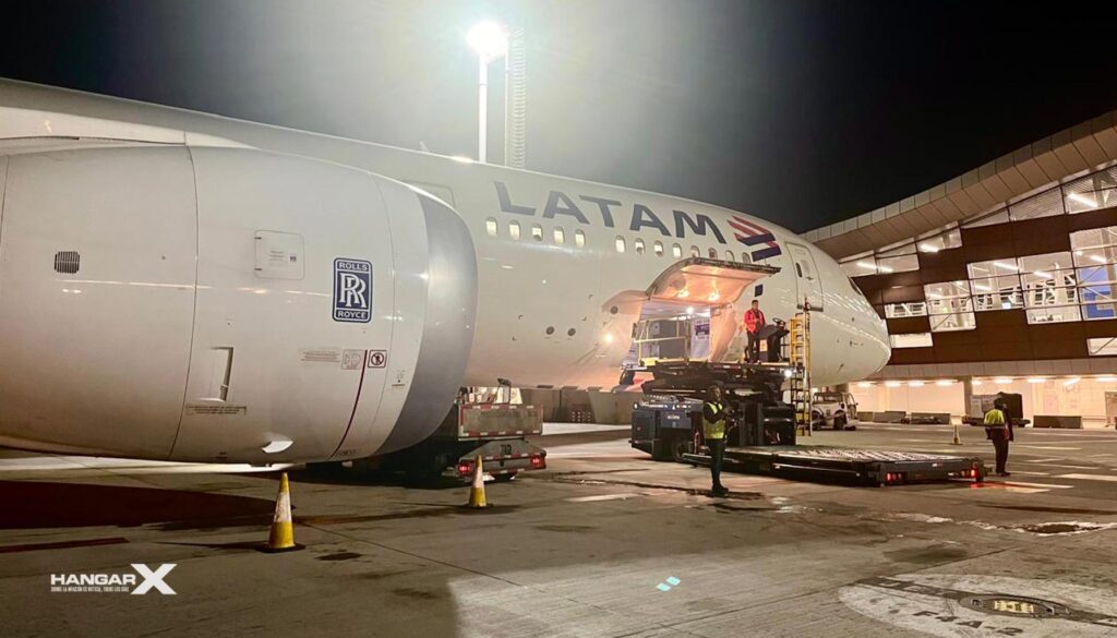 Avión de LATAM Cargo cargando salmón chileno fresco en el aeropuerto de Santiago de Chile, durante la noche.
