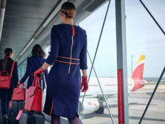 Tripulación de cabina de Iberia caminando hacia un avión estacionado en el aeropuerto, simbolizando los nuevos vuelos económicos disponibles en 2025