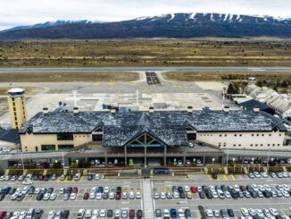 Vista aérea del Aeropuerto de Bariloche con nieve en invierno y gran cantidad de vehículos en el estacionamiento