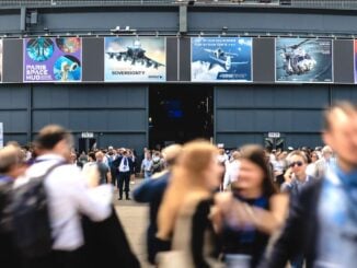 Visitantes ingresando al pabellón principal del Paris Air Show 2025 en Le Bourget, rodeados de banners de defensa y aviación.