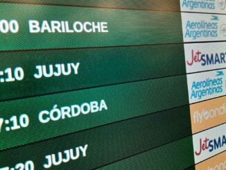 Pantalla de vuelos en aeropuerto argentino con destinos como Bariloche, Jujuy y Córdoba durante las vacaciones de invierno