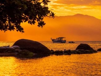 Atardecer en Florianópolis con embarcaciones sobre el mar