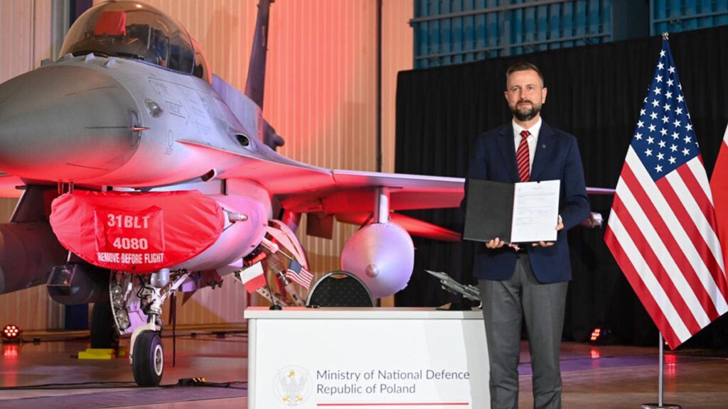 Ministro de Defensa de Polonia junto a un F-16 durante la firma del acuerdo para modernizar la flota al estándar F-16 Viper con Lockheed Martin.