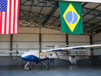 Avión autónomo agrícola Pelican 2 de Pyka en hangar con banderas de Estados Unidos y Brasil