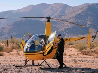 Helicóptero Robinson R22 amarillo en tierra durante operación de vuelo en el desierto