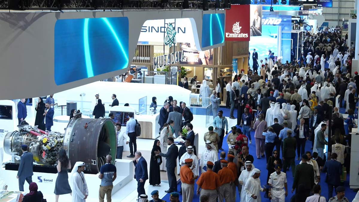 Afluencia de público y exhibiciones en el Dubai Airshow 2025, con stands de empresas aeronáuticas y motores expuestos en el recinto ferial.