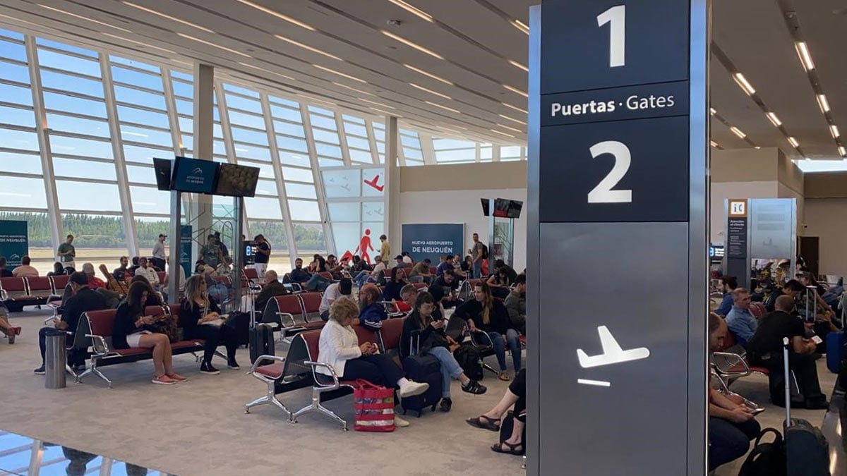Sala de embarque del aeropuerto de Neuquén con pasajeros esperando en las puertas 1 y 2