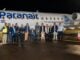 Autoridades y ejecutivos posan frente al avión de Paranair tras el vuelo inaugural de los vuelos Montevideo-Rivera en el aeropuerto de noche.