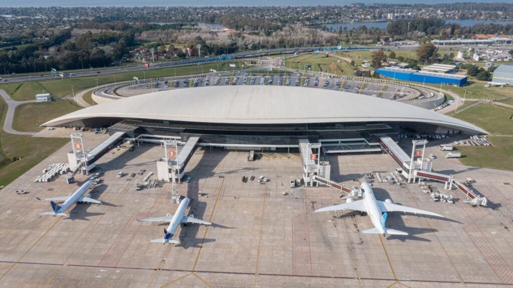Vista aérea panorámica de la terminal del Aeropuerto Internacional de Carrasco (MVD) en Montevideo, Uruguay, con aeronaves de aerolíneas comerciales estacionadas en las mangas.