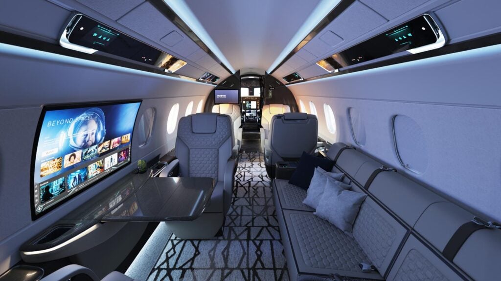 Interior de la cabina del Embraer Praetor 600E configurada con un diván frente a la pantalla táctil Smart Window OLED.