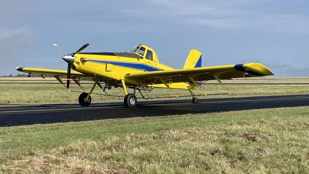 Air Tractor AT-502B: Avión agrícola histórico número 5.000 fabricado por la compañía, con esquema de pintura amarillo y azul, posicionado sobre la pista.
