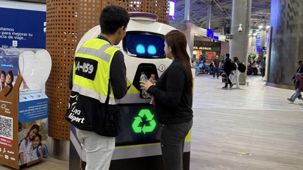 Pasajeros interactúan con IRBin, el robot con inteligencia artificial de Lima Airport para el reciclaje de botellas plásticas en Perú.