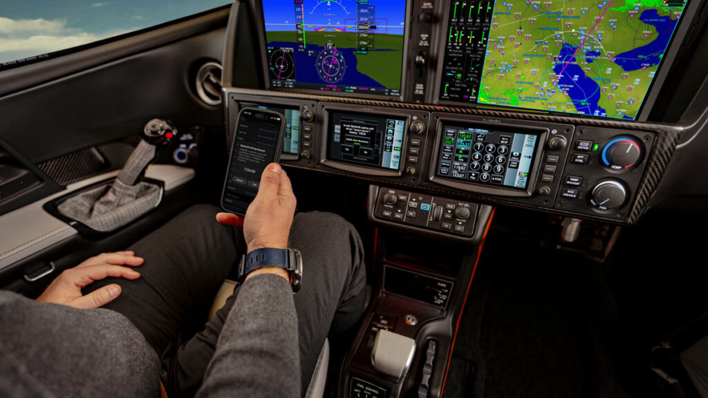 Piloto configurando la conectividad de su teléfono móvil en la cabina de mando con aviónica avanzada del Cirrus Vision Jet G3.
