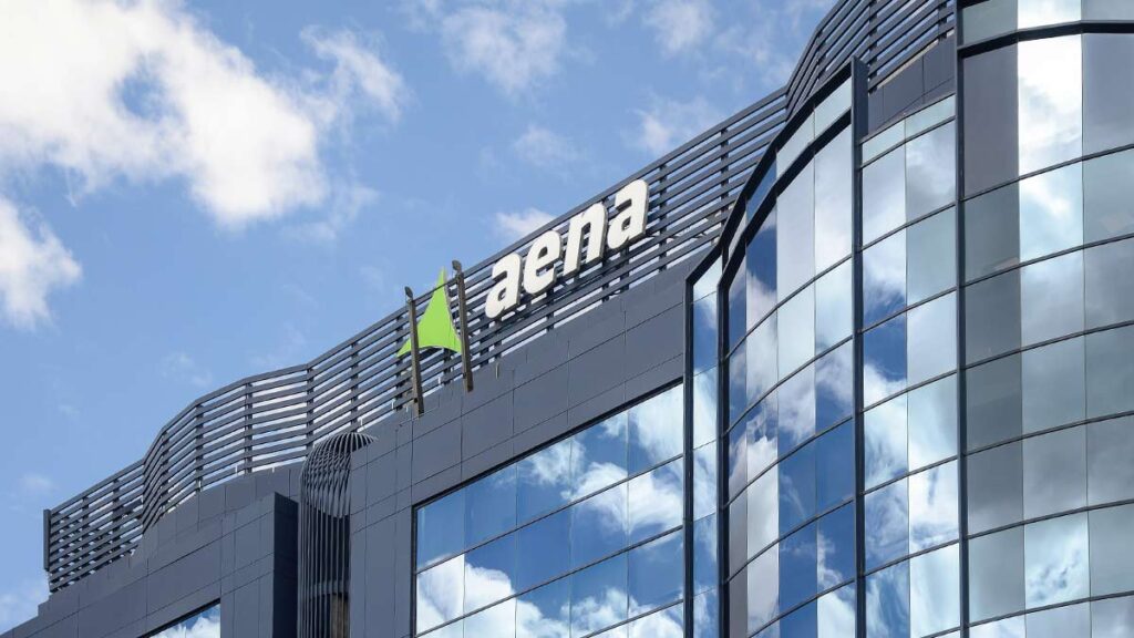 Fachada de cristal del edificio corporativo con el logotipo de Aena, empresa gestora de los aeropuertos en España.