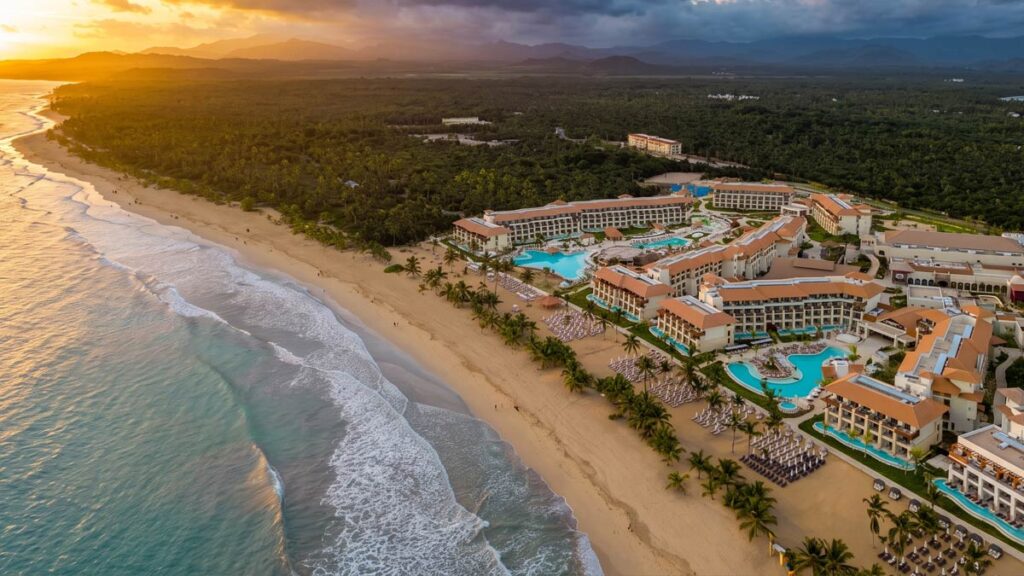 Vista aérea de un resort de lujo emplazado sobre una playa virgen y rodeado de selva tropical en Miches, República Dominicana.